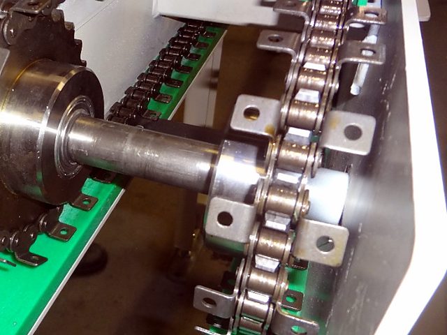 Rollenkette mit beidseitigen Winkellaschen im Umlauf über das Kettenrad